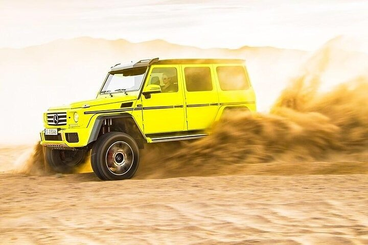 Experience the rush of adventure as a luxurious Mercedes AMG G63 glides through the golden sands of the Arabian Desert providing unmatched moments amidst stunning dune landscapes.